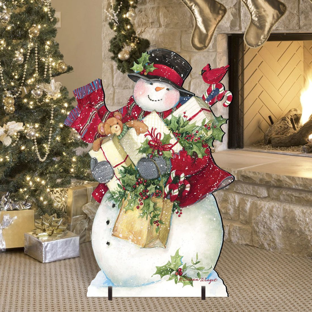 Standing Christmas yard decoration sign of a snowman holding gifts, red hat and holly