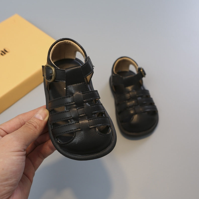 Black toddler closed-toe woven sandals close-up, hook-and-loop ankle strap