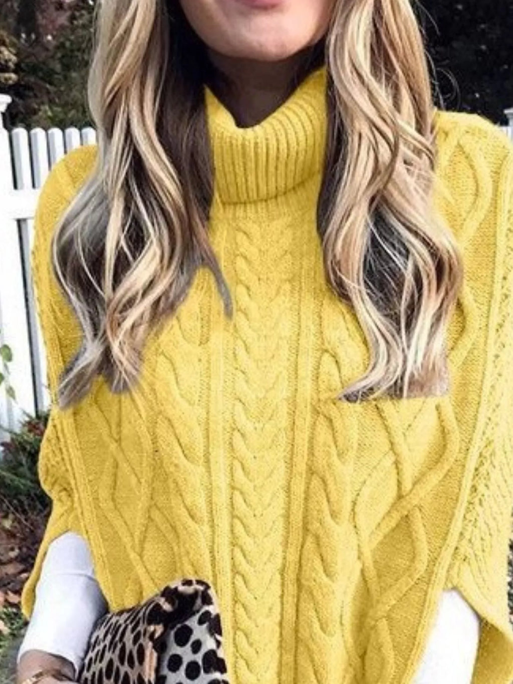 Yellow chunky cable-knit turtleneck poncho with ribbed neck and cable pattern