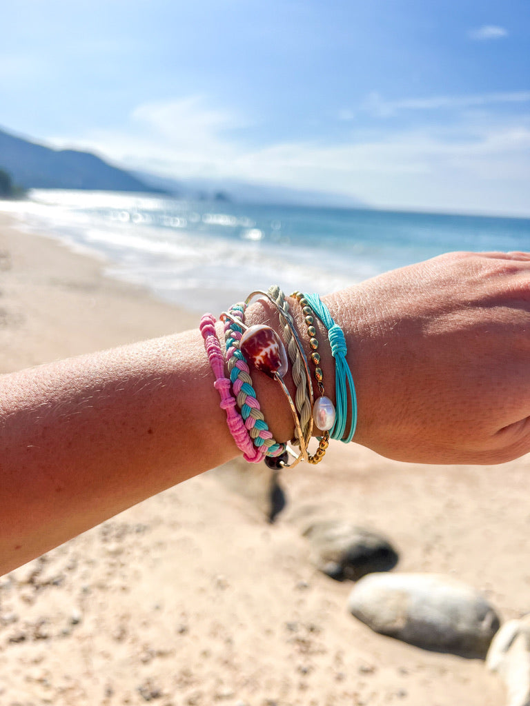 Multi-color braided hair tie bracelets with gold coin charms on wrist