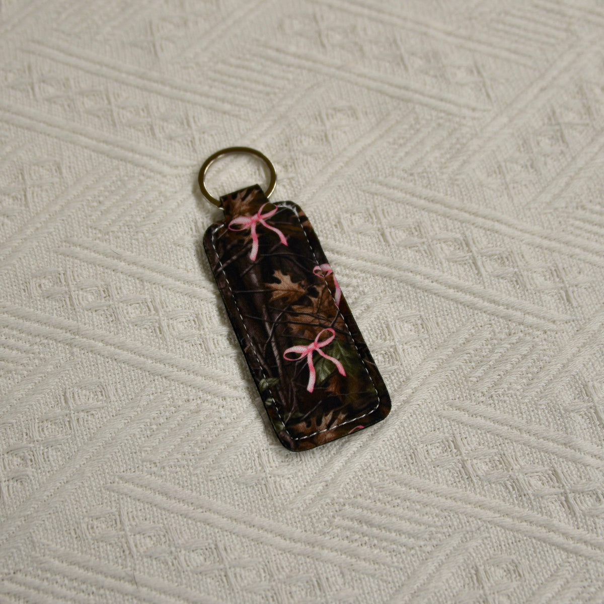 Camo chapstick holder keychain with pink bow tie and gold-tone key ring