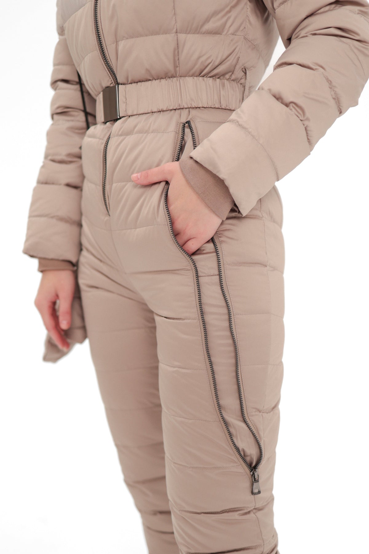 Beige down-insulated snow suit detail: zip fly pocket and ribbed waist belt.