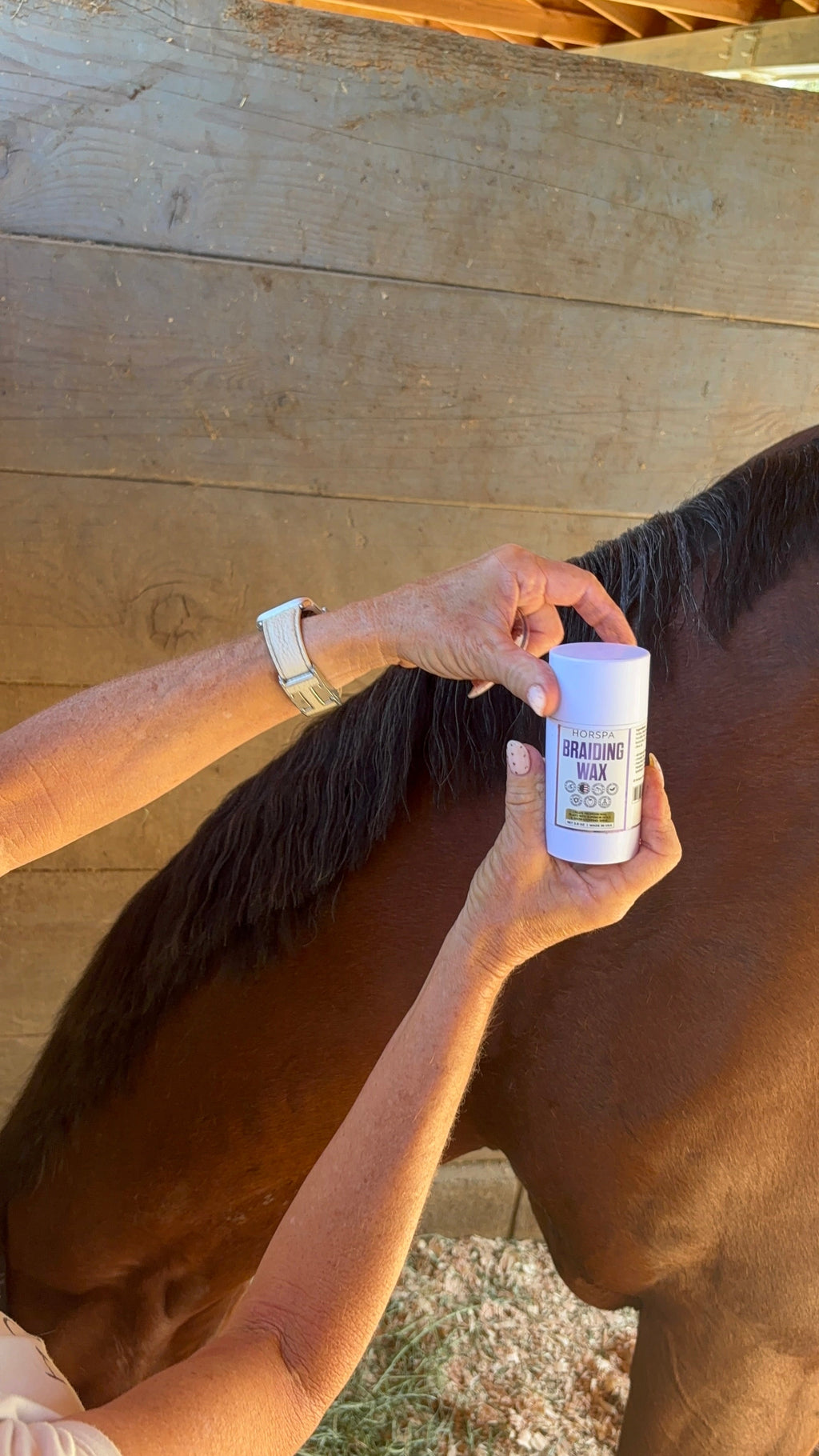 Braiding wax applied to a horse mane, hand holding a white cylindrical container