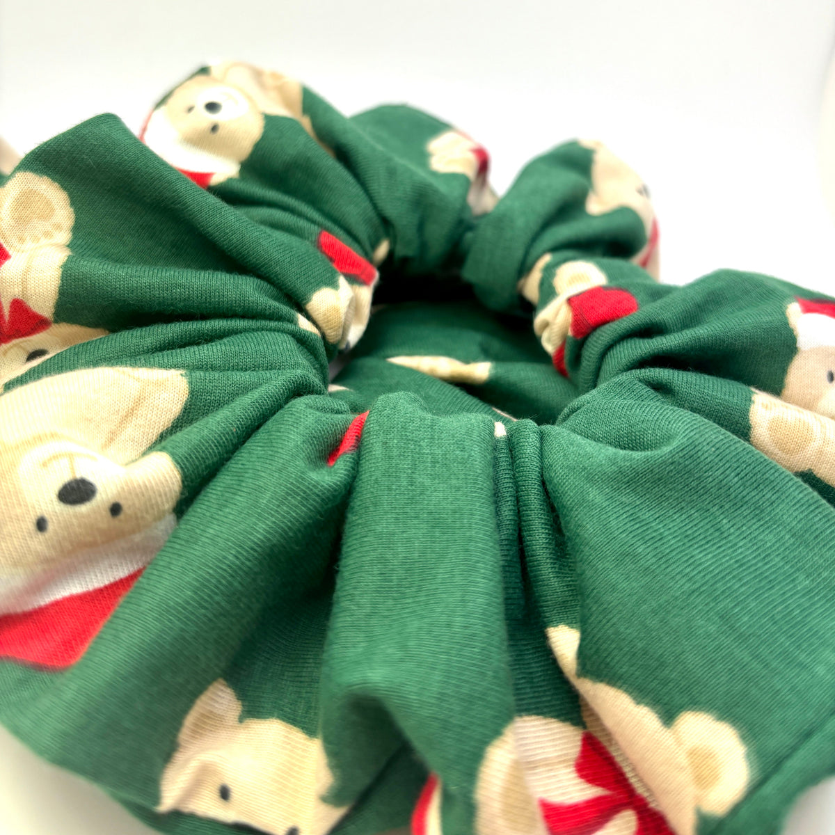 Green teddy bear scrunchie close-up with gathered center and holiday print