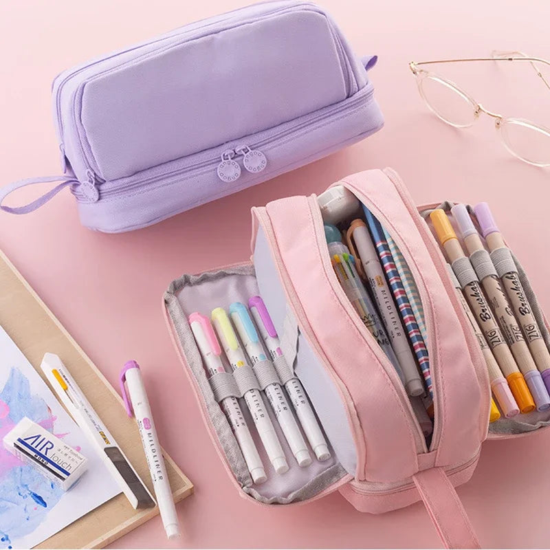 Lavender and pink zippered pencil bags open, showing colorful markers inside compartments.