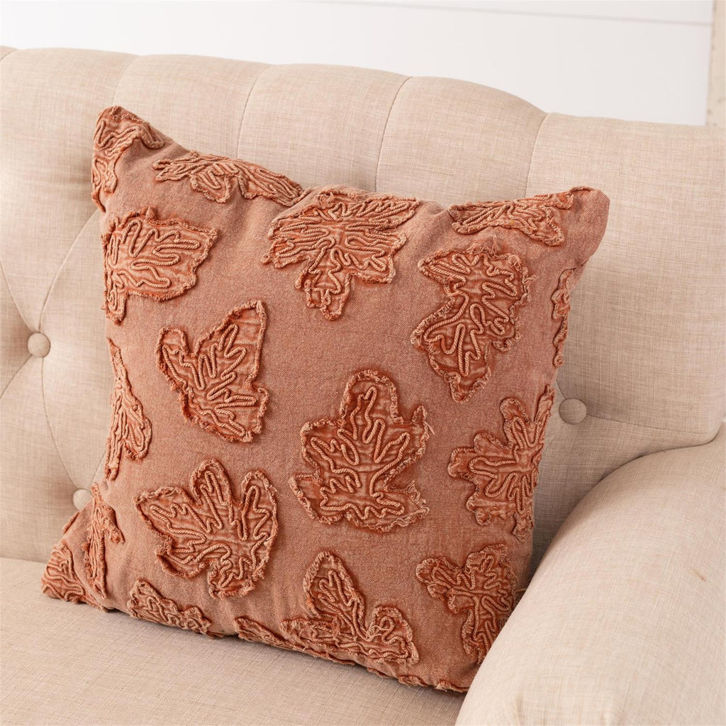 Orange stonewashed throw pillow with raised leaf embroidery, 3/4 angle, square