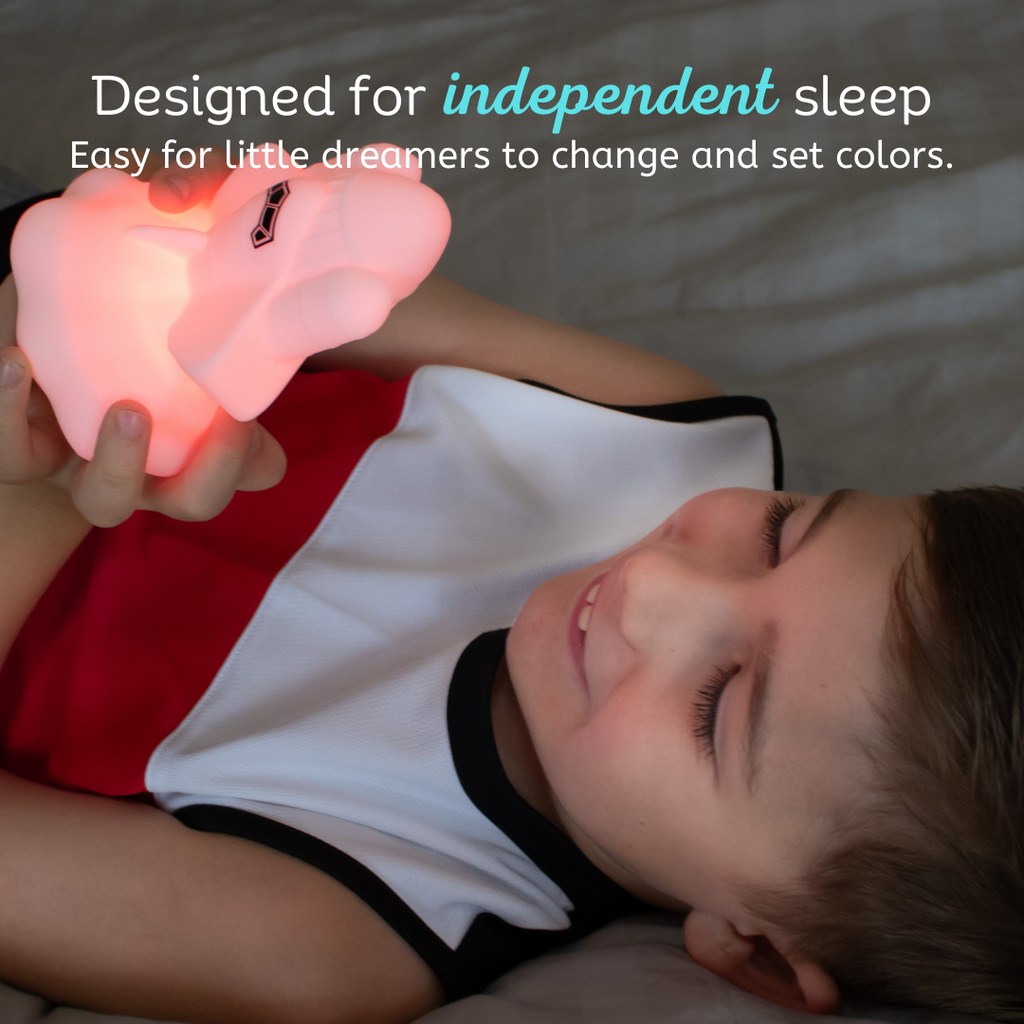 White UFO touch night light casting pink glow at bedtime