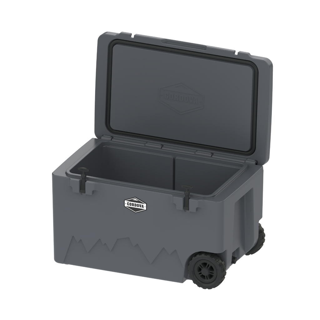 125 qt wheeled cooler with lid open, front access panel, logo badge, and wheels; blue-gray