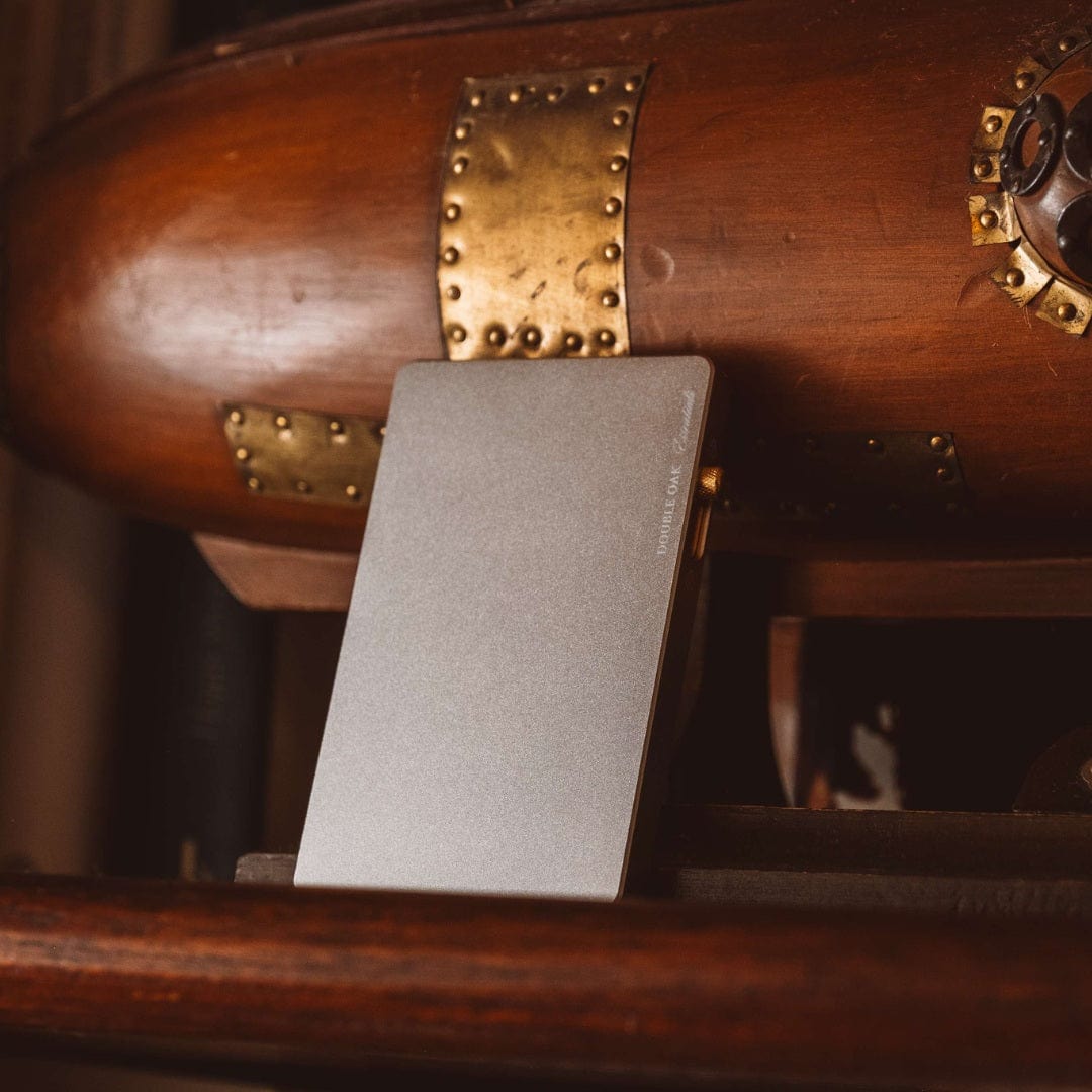 Silver pop-up cardholder standing upright on a wooden surface.