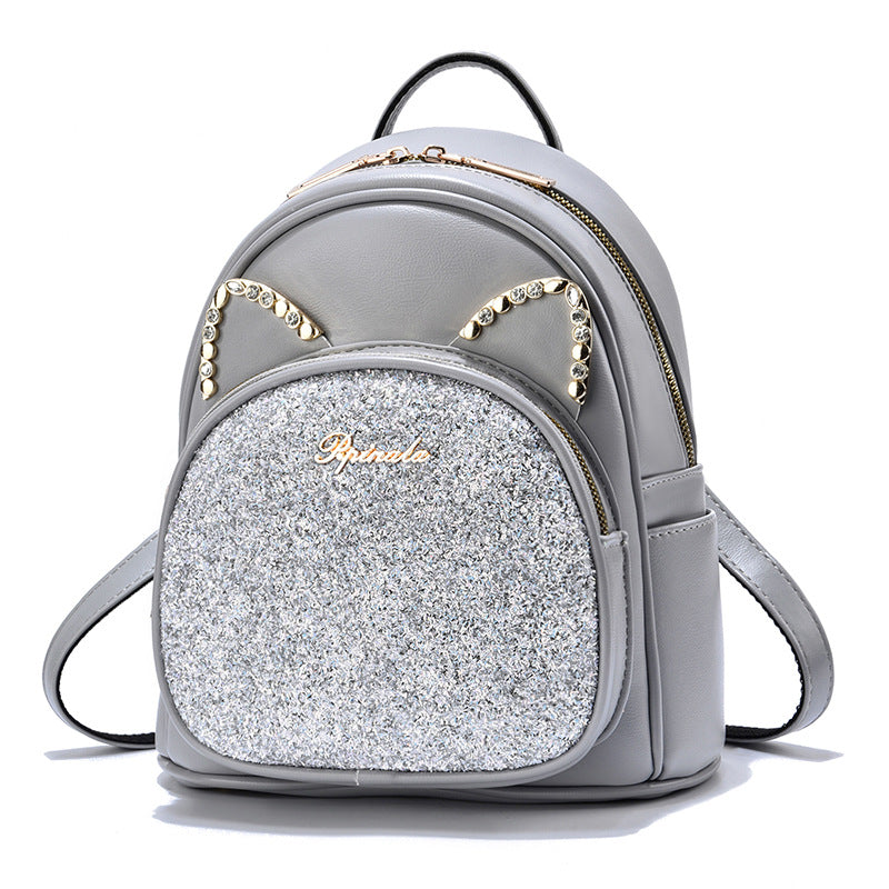 Gray PU leather backpack with silver glitter front pocket, rhinestone arch detail, front zipper.