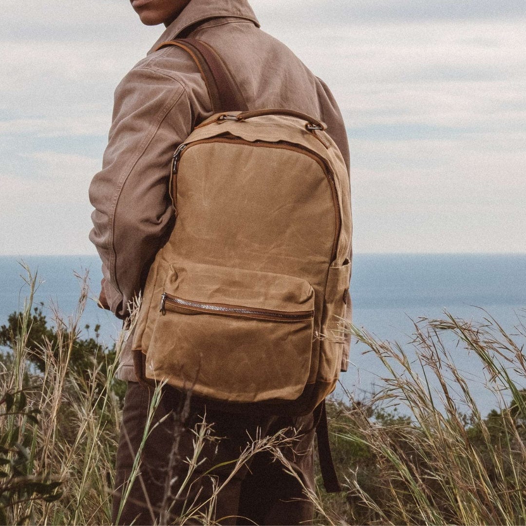 Sand waxed canvas backpack with front pocket and leather straps, side view
