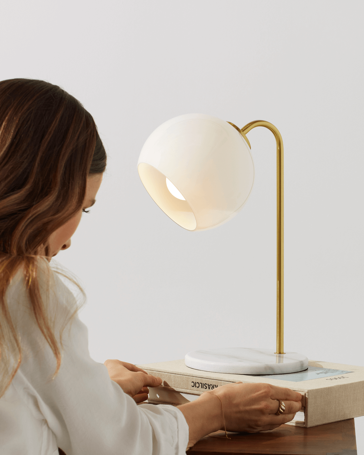 Krystal table lamp with glowing round shade on white marble base