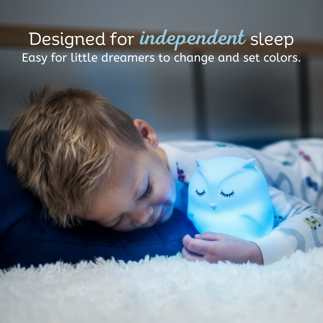 Blue-glowing owl touch night light held by a child in bed