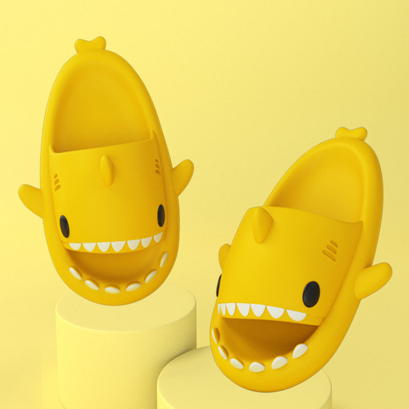 Yellow shark-shaped slide sandals on pedestal bases, open toe with white teeth