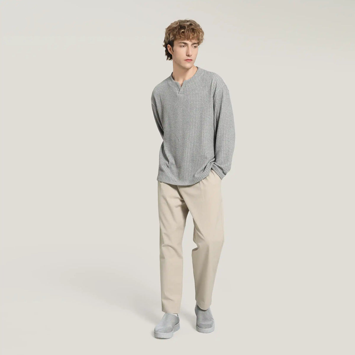 Gray 3D-printed slip-on sneakers on model with gray sweater and light trousers
