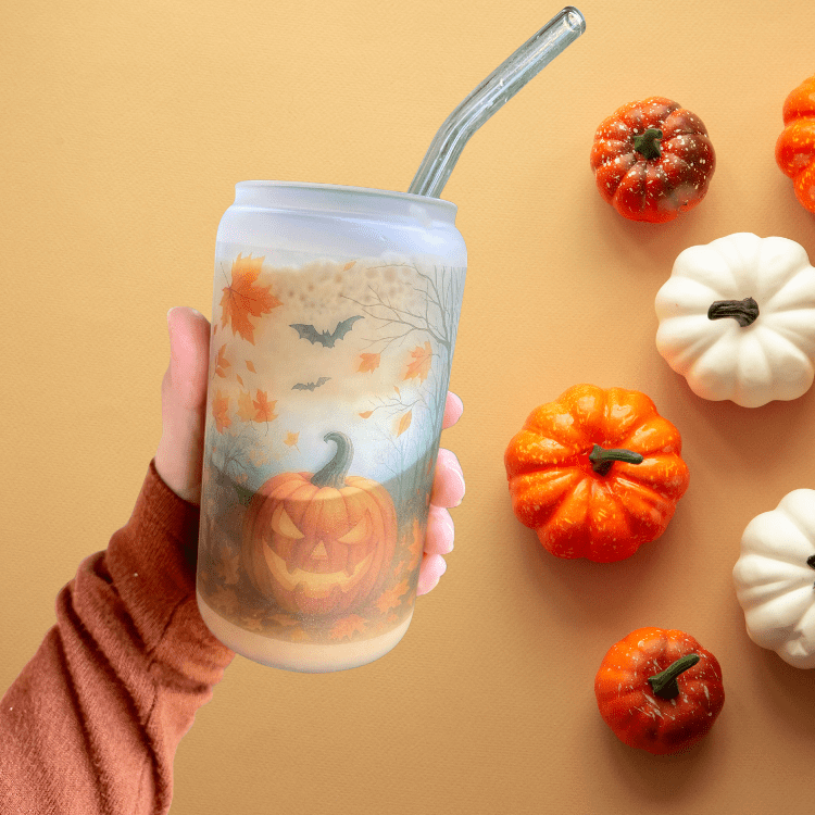 Frosted Halloween glass tumbler with straw and jack-o'-lantern, bats, and leaves