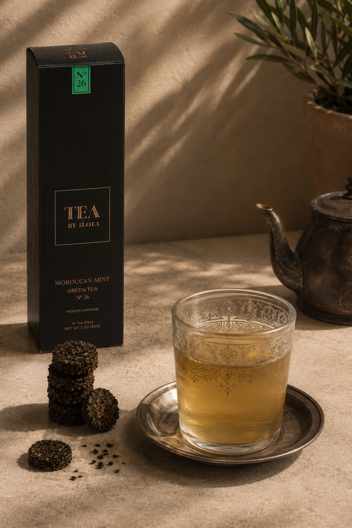 Moroccan mint tea box with compressed tea discs and a glass of brewed tea