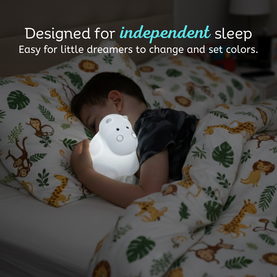 LumiPets Honey hippo touch night light near a sleeping child on a bed
