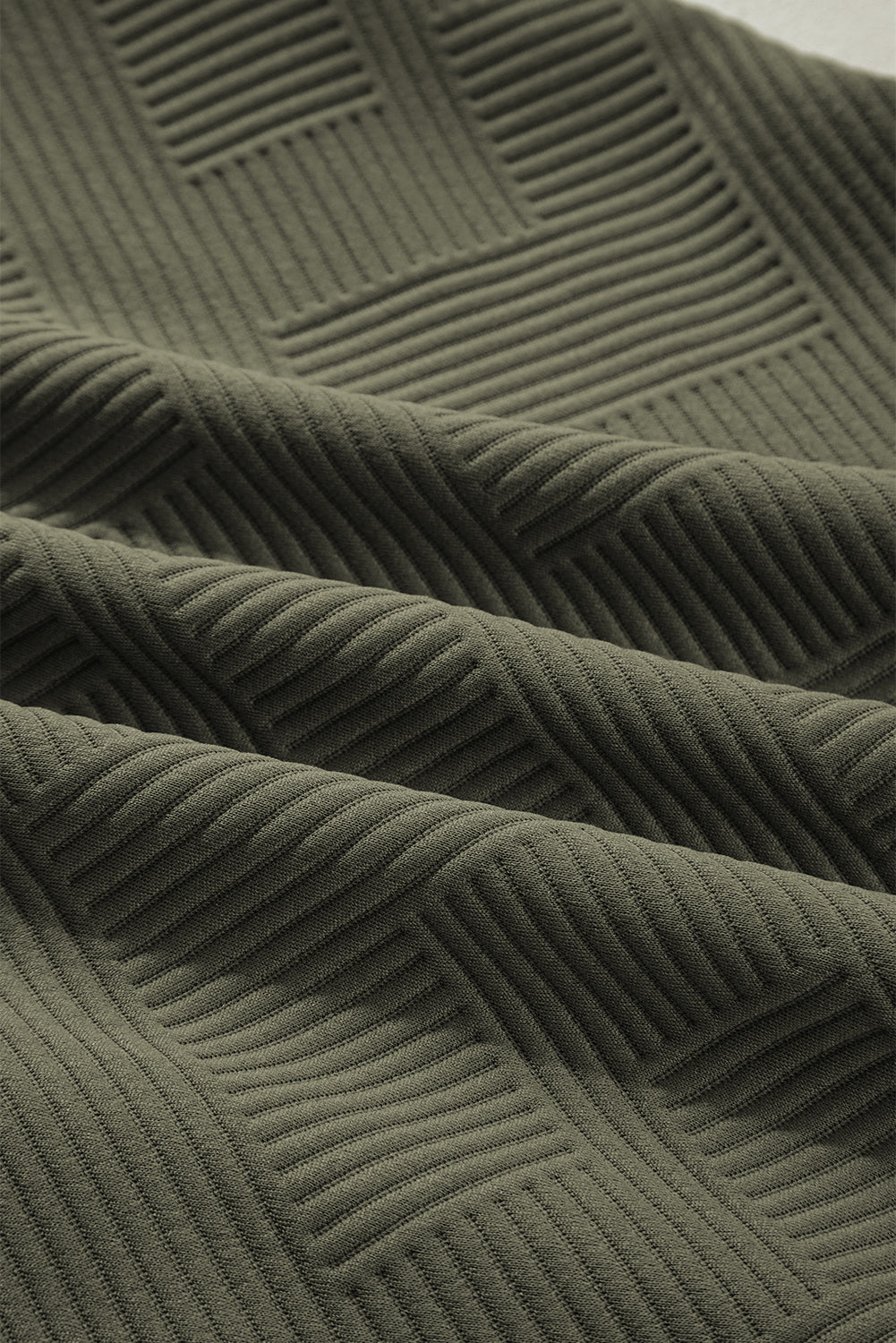 Close-up of jungle green textured fabric with geometric rib pattern