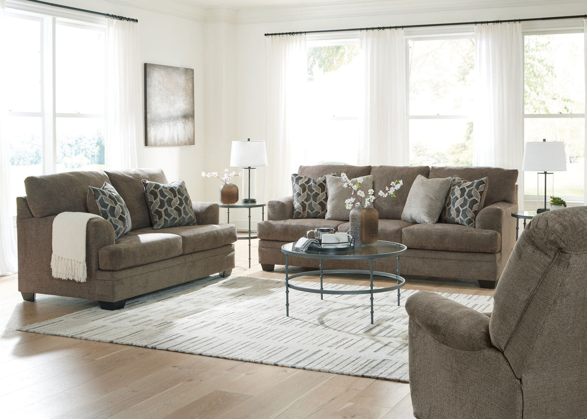 Tan fabric living room set with sofa, armchairs, and patterned accent pillows
