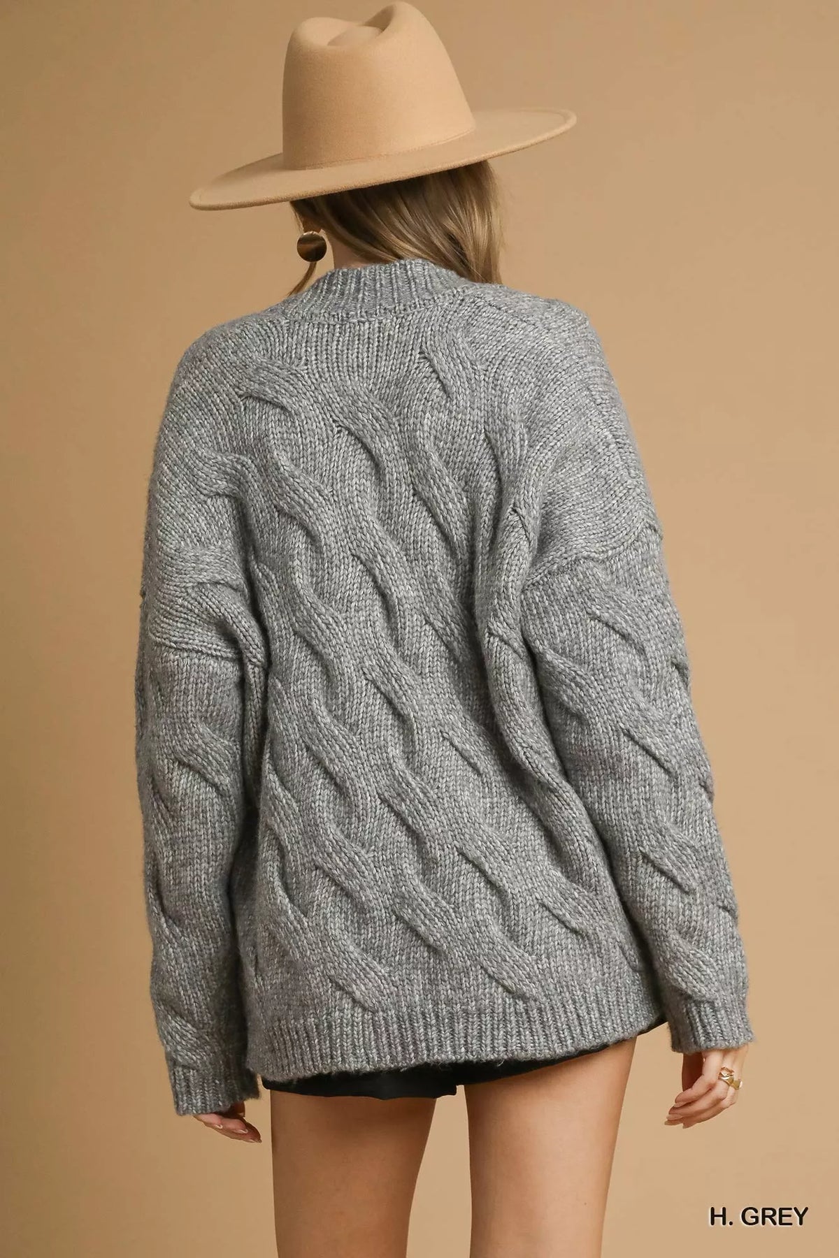 Grey chunky cable-knit open-front cardigan, cable pattern visible on back, long sleeves
