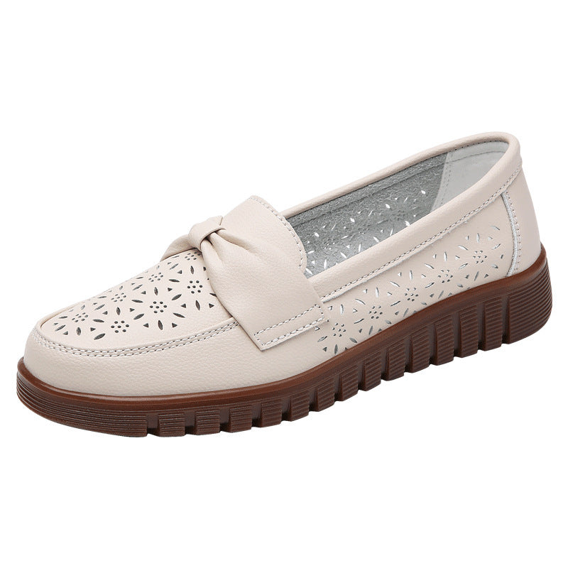 Women’s beige perforated flat loafer with bow, stitched upper, and chunky rubber sole