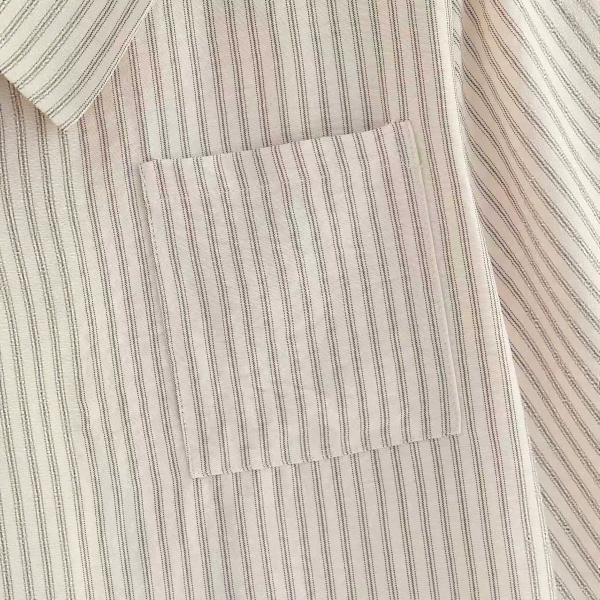 Beige striped short-sleeve shirt chest pocket detail with stitched edge