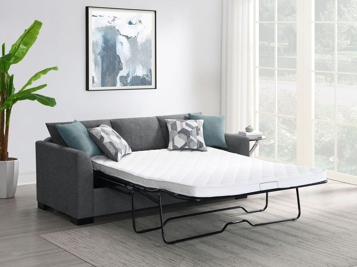 Grey sleeper sectional chaise sofa with teal pillows and mattress extended for sleeping