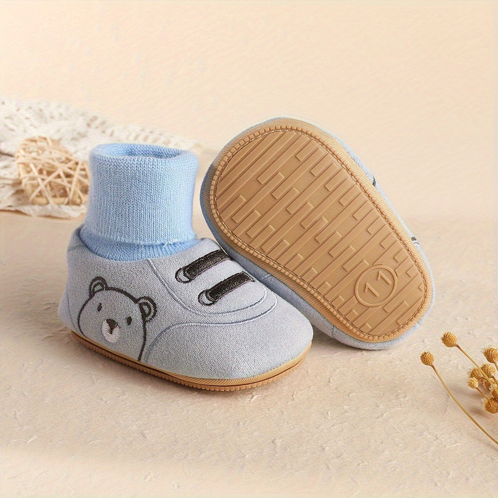 Light blue baby sock booties shown with outsole detail and bear face