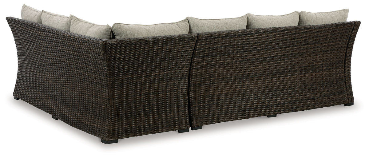 Sectional sofa with dark brown wicker sides and light beige seat cushions