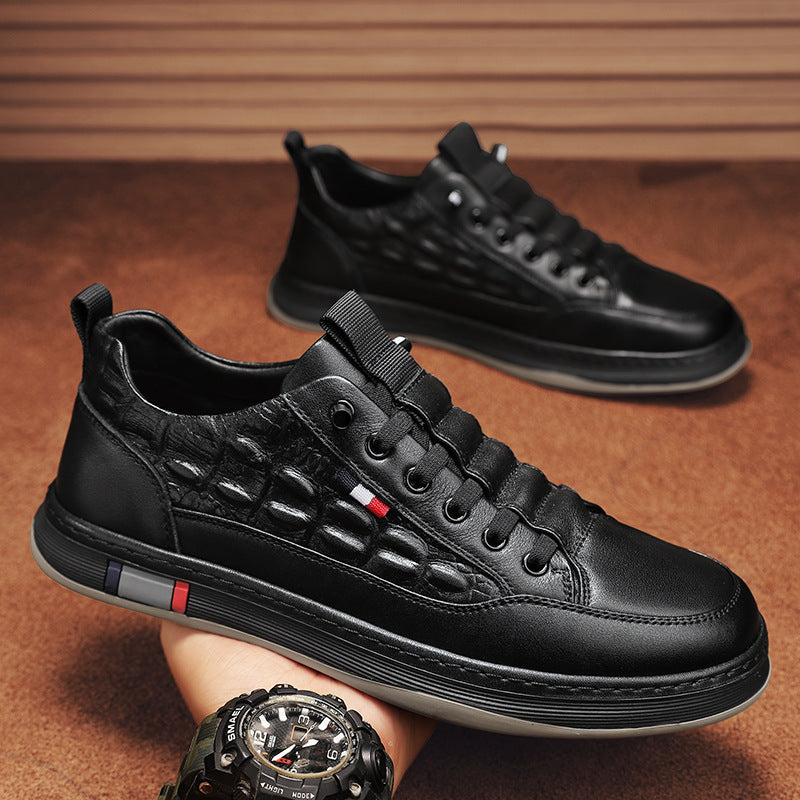 Black leather-look lace-up sneakers with textured upper and striped sole trim.