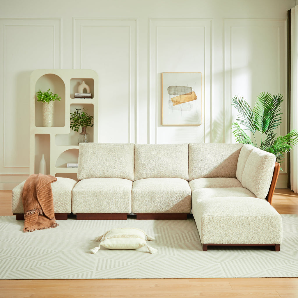 Sesame boucle sectional sofa with chaise modules and a folded terracotta throw