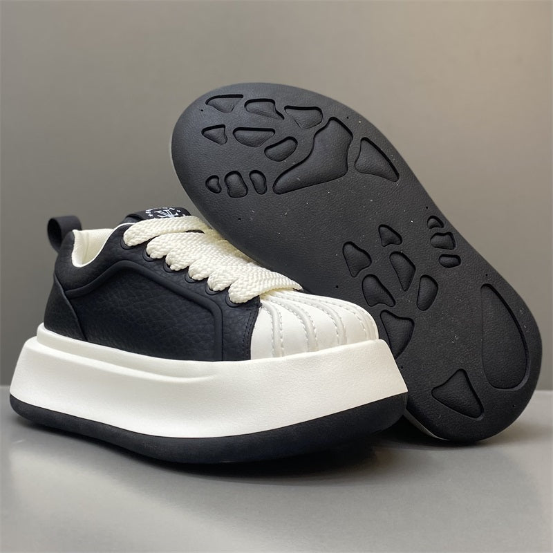 Leather shell-toe low-top sneakers with thick sole; navy upper, outsole tread visible