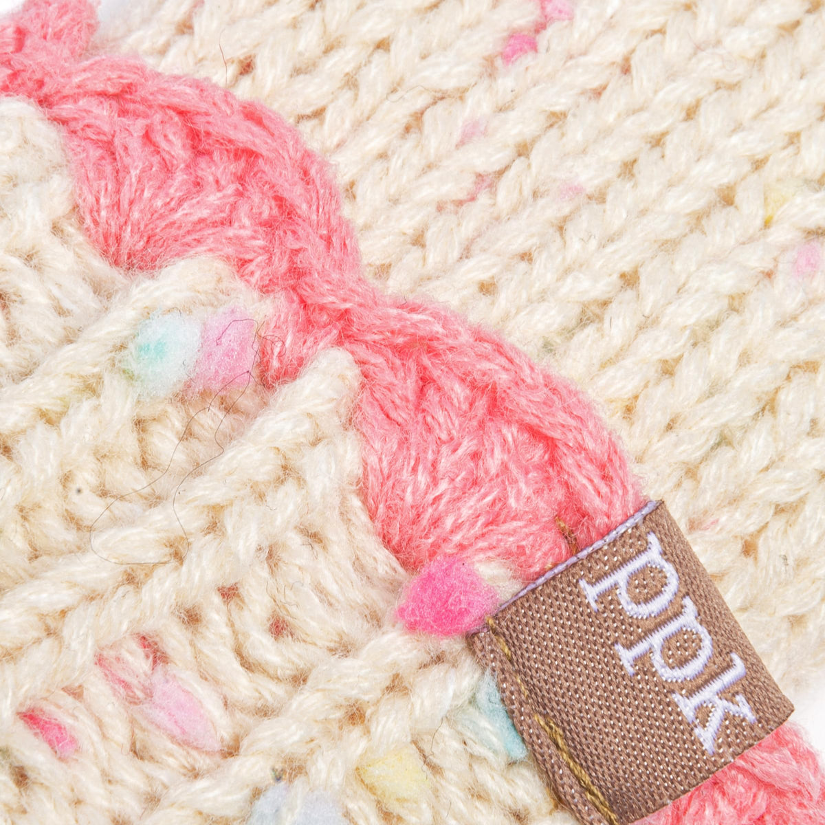 Cream knit mitten detail with pink fabric accent and PPDS woven brand tag