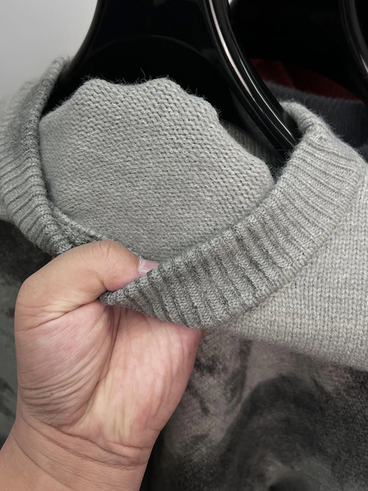 Gray ribbed knit round neck sweater sleeve and cuff detail with mottled pattern