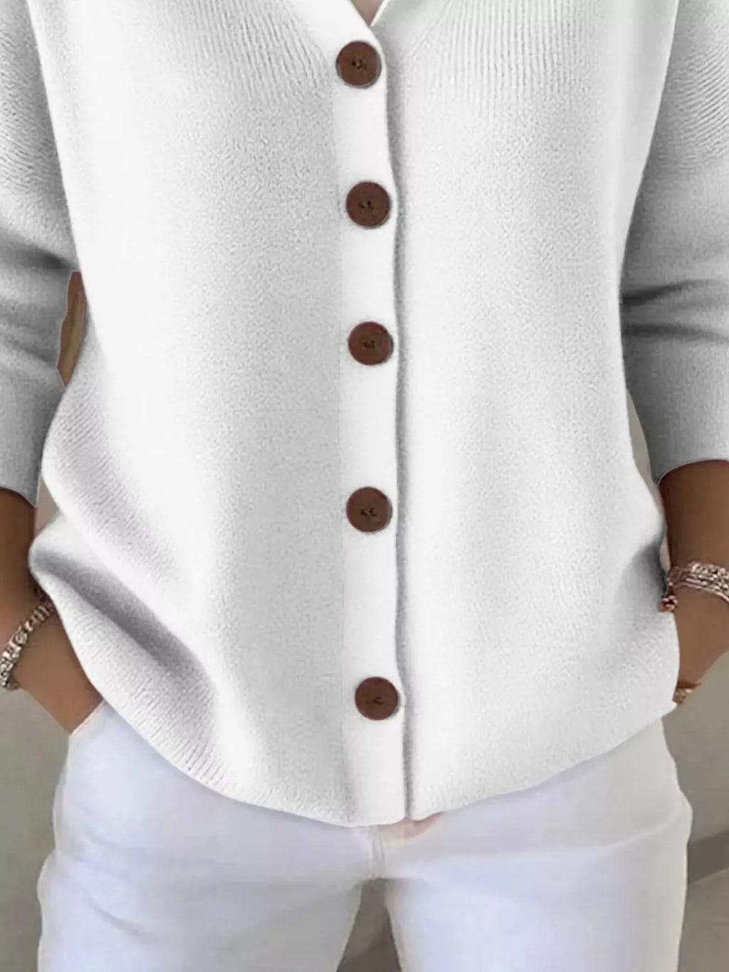 White hooded knit cardigan close-up of front buttons and ribbed texture