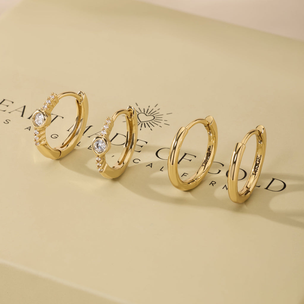 Gold bezel hoop earrings set with small round stones, shown as matching pairs