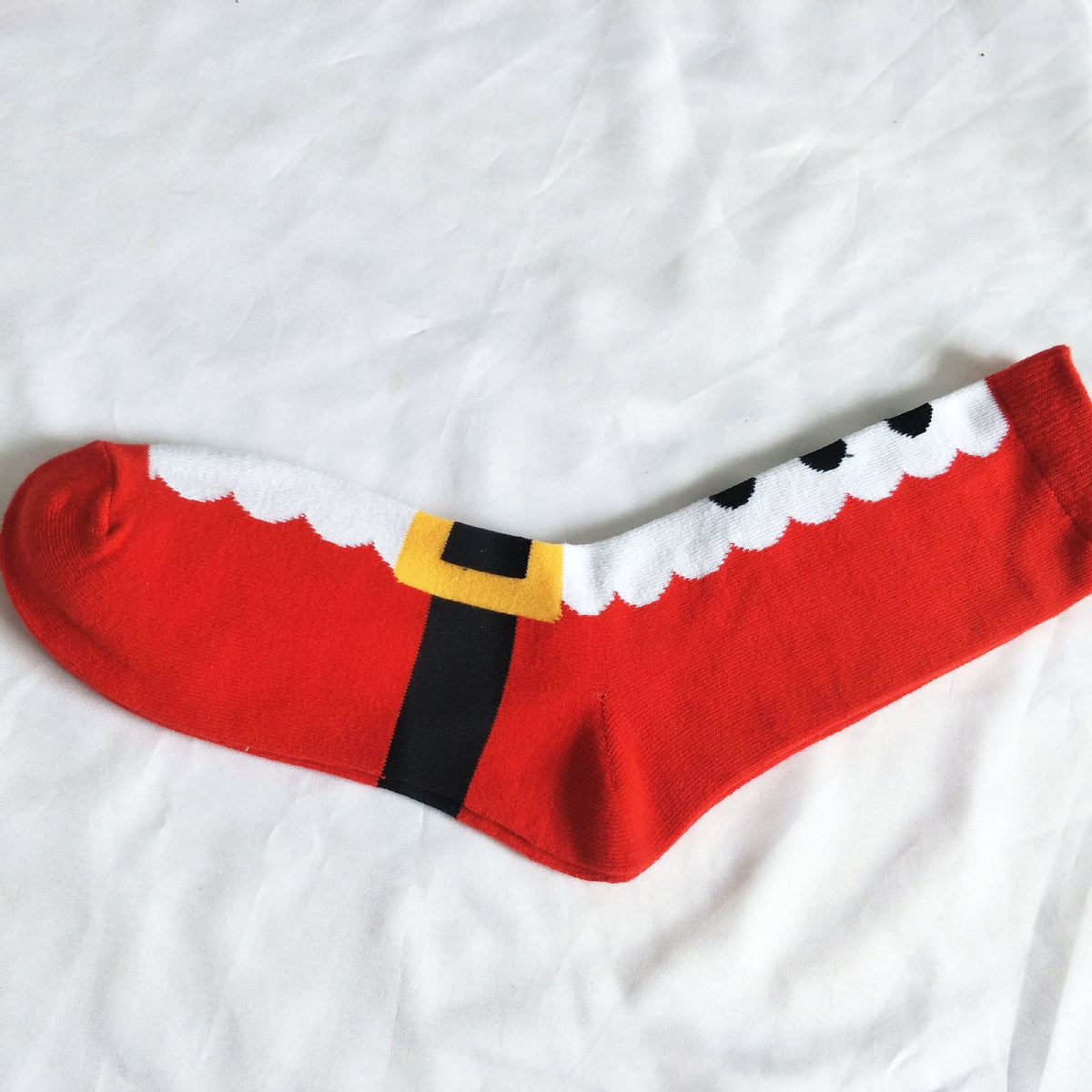 Red Santa socks with white fur trim and black-and-yellow buckle detail at cuff