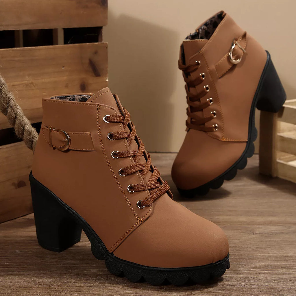Tan lace-up ankle boots with chunky heel, buckle strap at collar, rugged tread sole