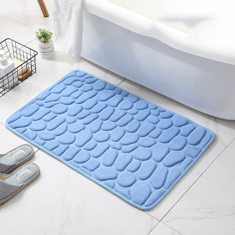 Light blue bathroom bath mat with raised pebble-texture dots, non-slip backing