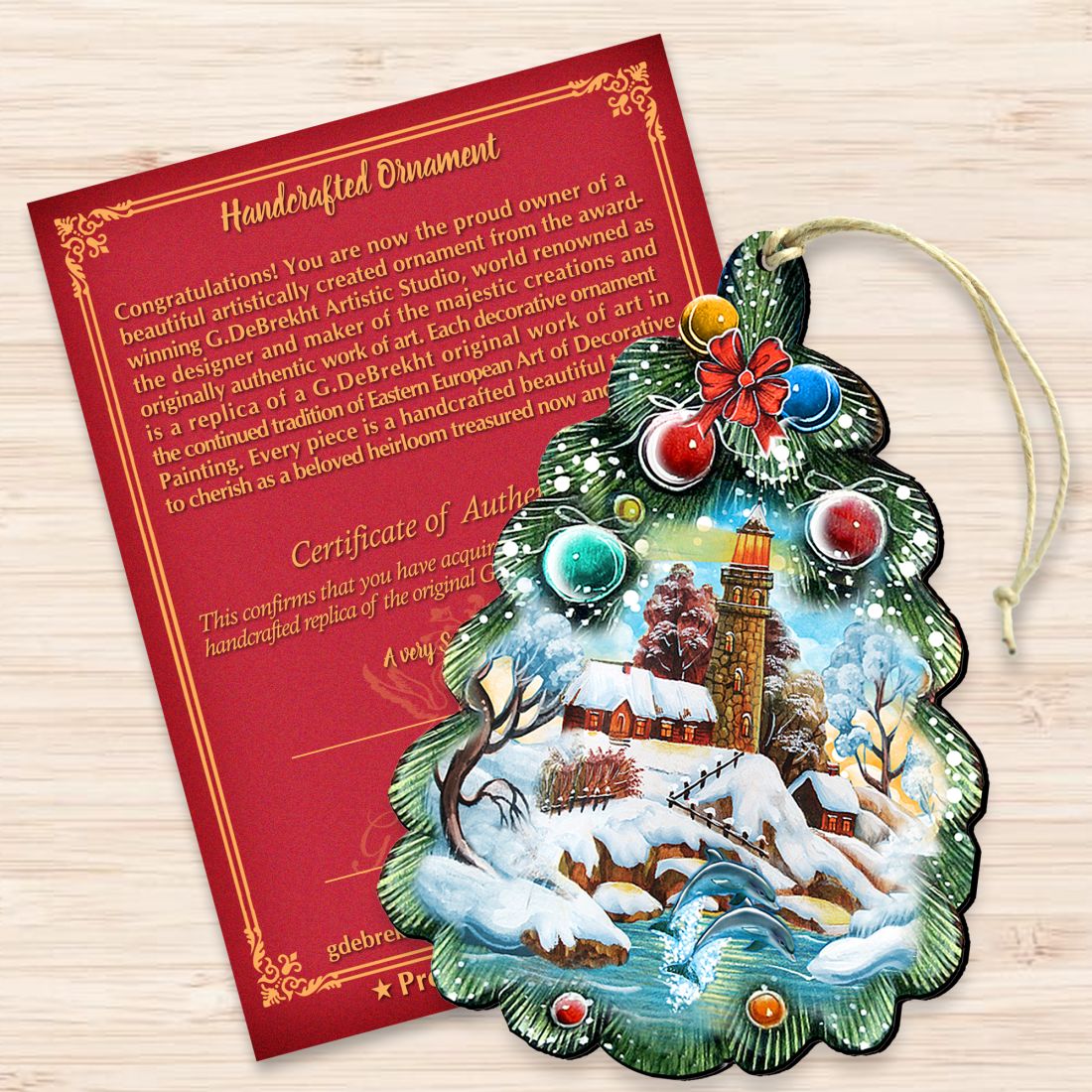 Wooden Christmas tree ornament with lighthouse scene and red flower topper, plus authenticity card