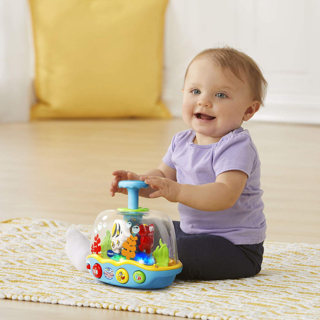 Toddler kneeling with lavender shirt and spinning ocean adventure aquarium toy
