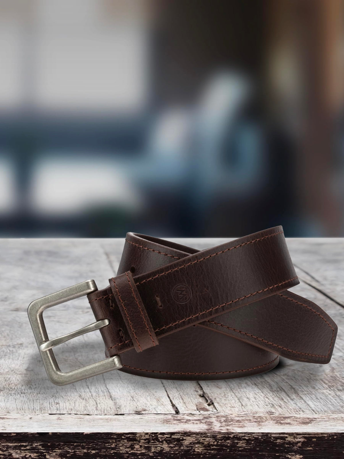 Brown leather belt with silver buckle, strap and tail shown flat