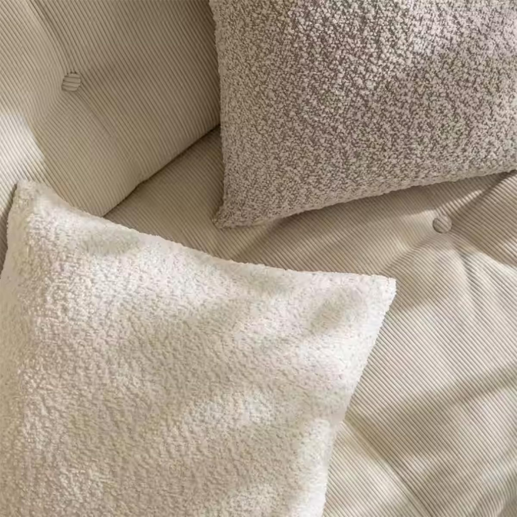 Bouclé-style throw pillow in brown and cream, with textured square pillows