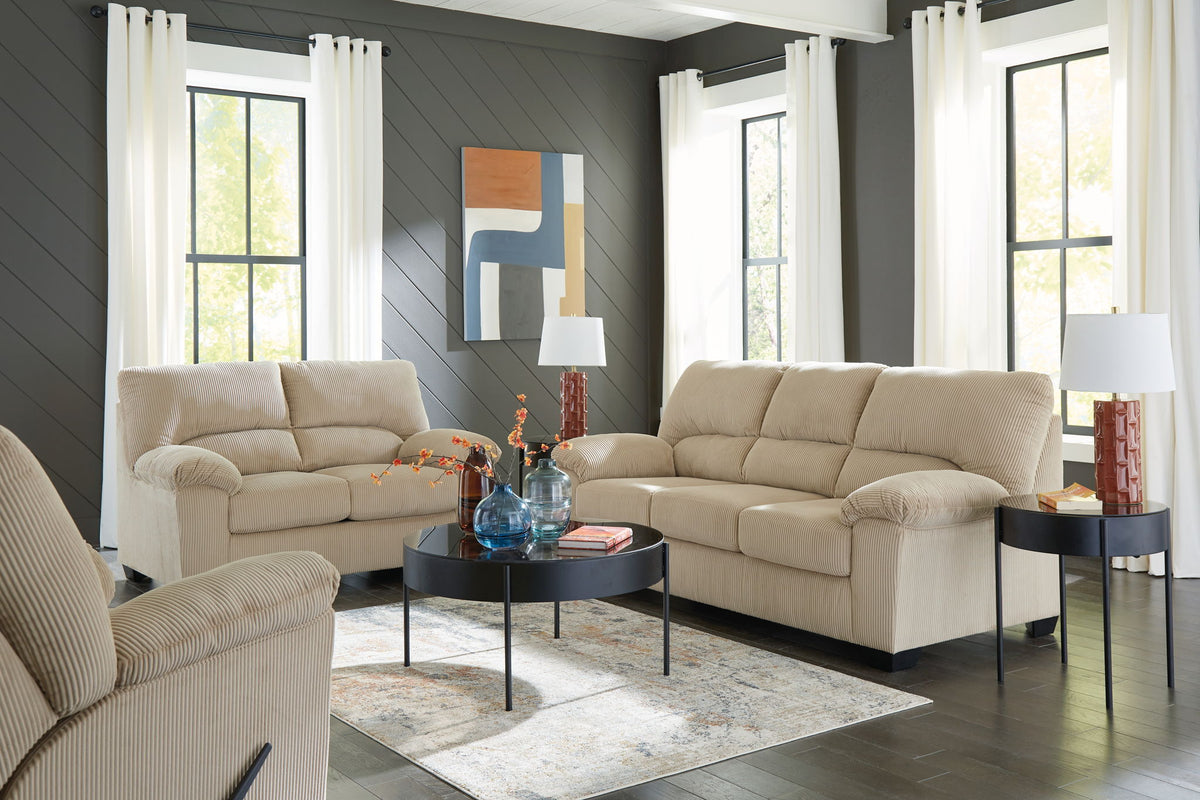 Beige sofa and loveseat set with tufted cushions and rolled arms