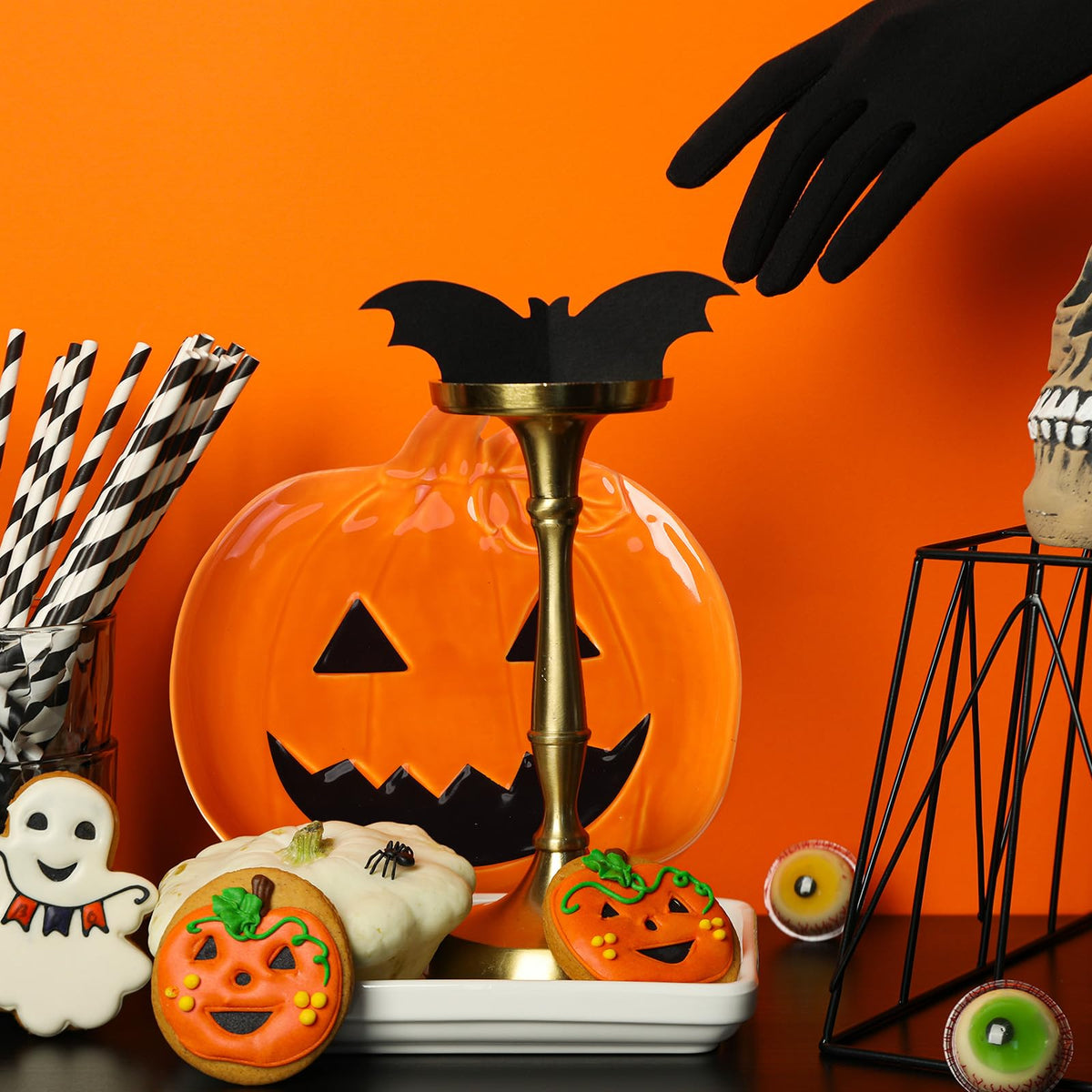 Orange jack-o'-lantern ceramic candy dish with carved face on party table