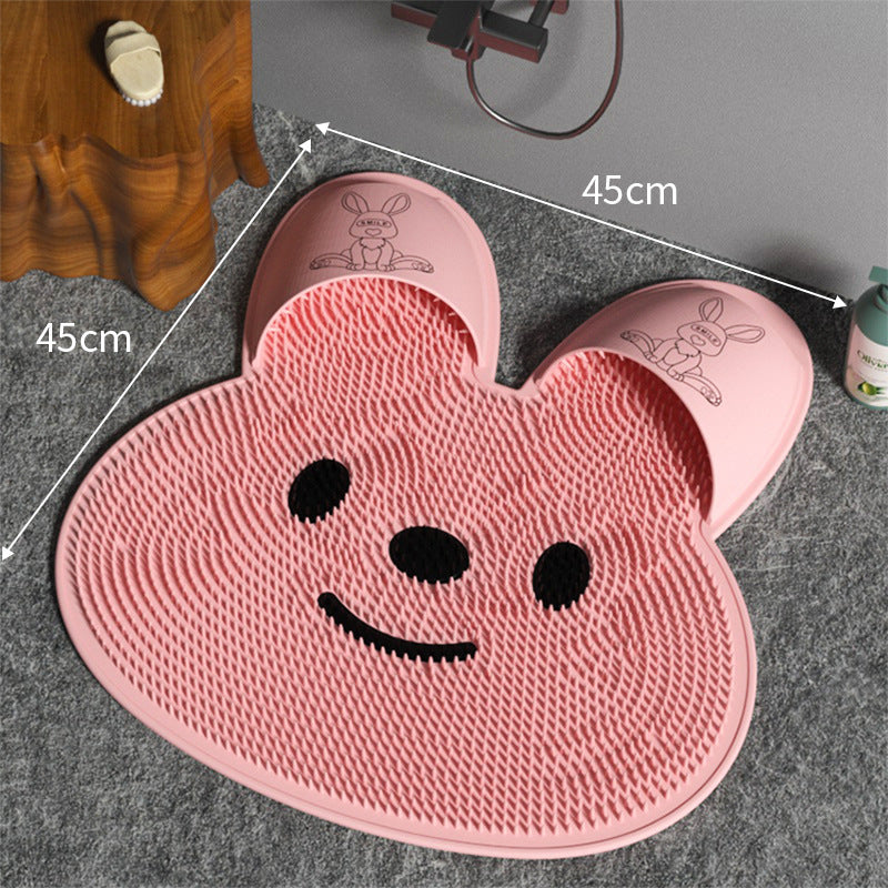 Pink silicone rabbit foot massage mat with raised texture and cartoon face