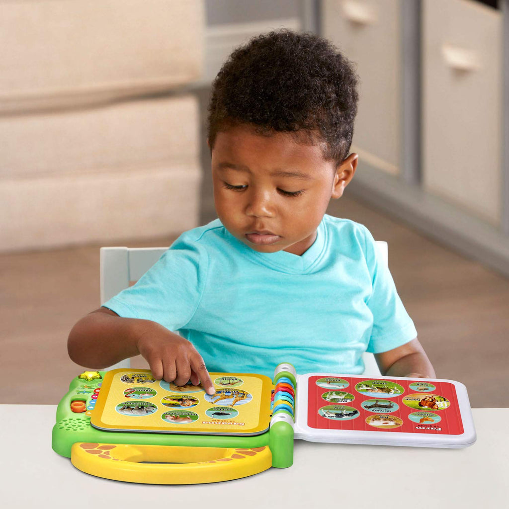 Toddler presses animal icons on an interactive book with green and yellow base