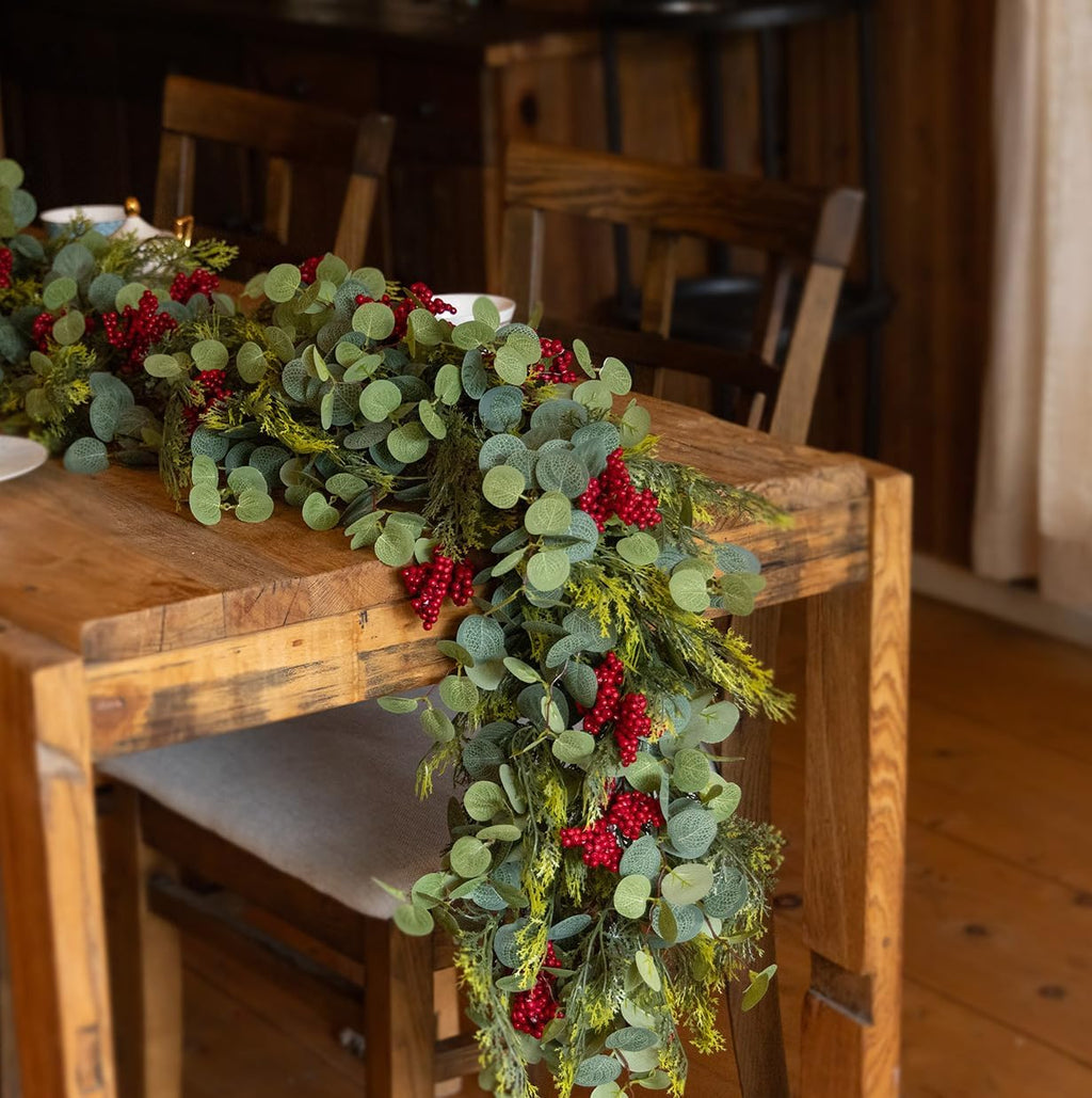 Artificial green garland swag with red berry clusters and pine-cypress needle accents
