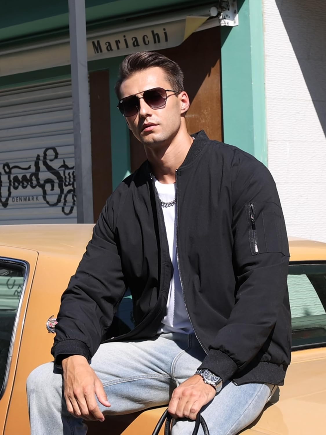 Men's black bomber jacket worn over a T-shirt, with stand collar and zip pocket